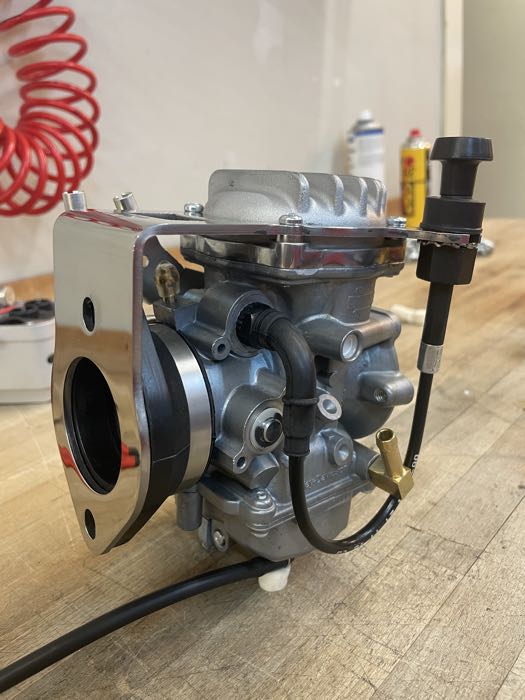 Kit di montaggio di Bates; per carburatori Keihin CV 1988→; per collettori Tillotson, Bendix e Keihin (a farfalla); acciaio inox, lucidato; distanzia fori fissaggio: 73 mm; spessore: 3 mm; Spagna; peso lordo: 400 g