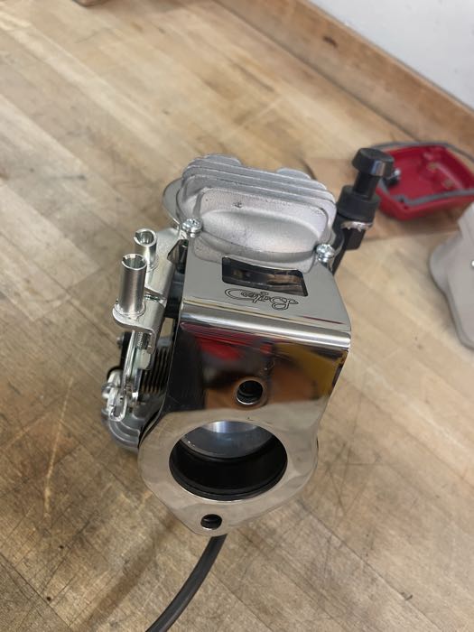 Kit di montaggio di Bates; per carburatori Keihin CV 1988→; per collettori Tillotson, Bendix e Keihin (a farfalla); acciaio inox, lucidato; distanzia fori fissaggio: 73 mm; spessore: 3 mm; Spagna; peso lordo: 400 g